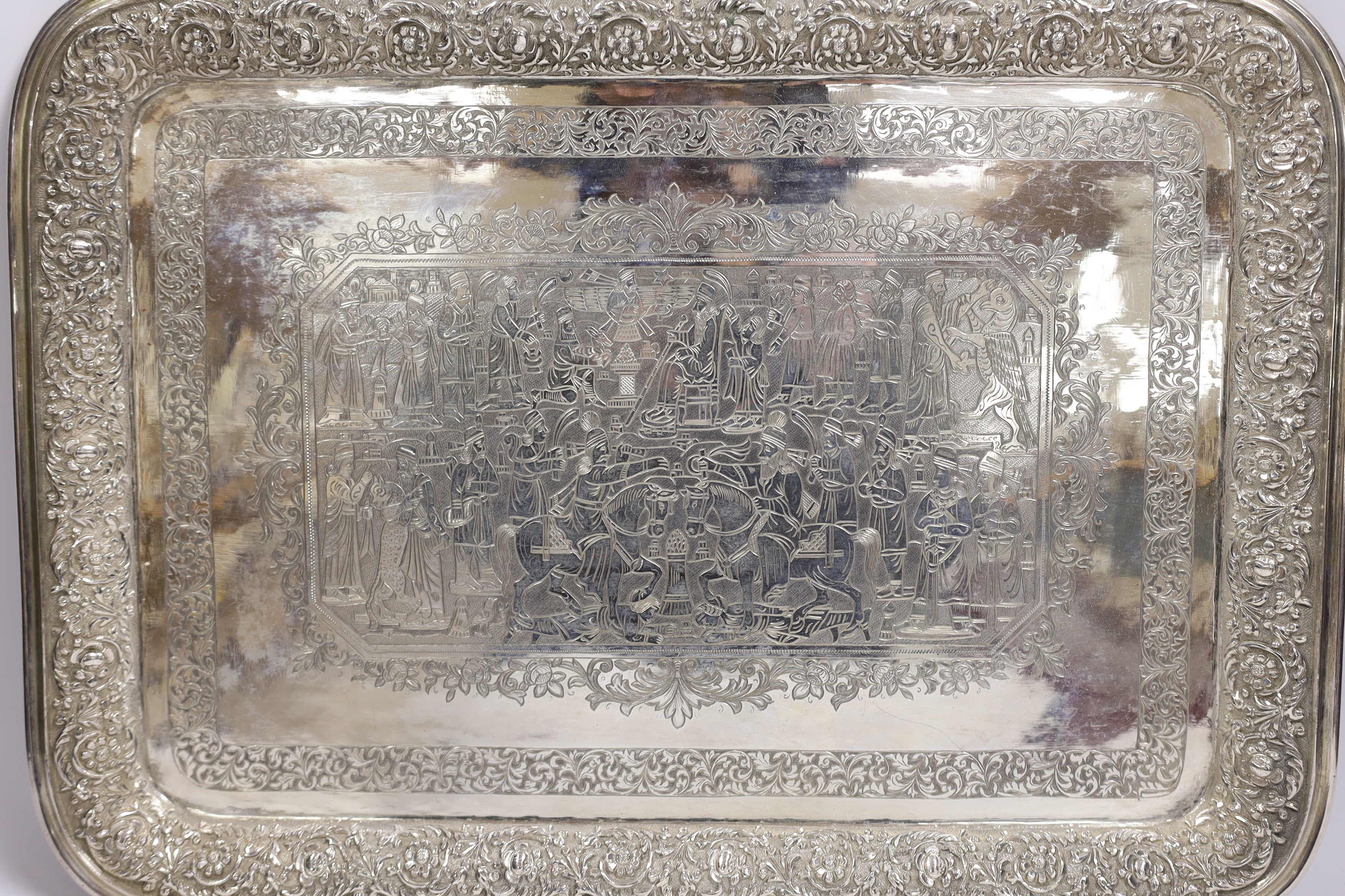 A Persian? engraved white metal tea tray, with embossed foliate border, 42cm, 46.4oz.